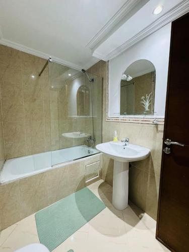 a bathroom with a shower and a sink and a tub at appartement de vacances achakar plage & piscine & wifi in Tangier
