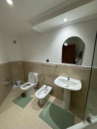 a bathroom with a sink and a toilet and a mirror at appartement de vacances achakar plage & piscine & wifi in Tangier
