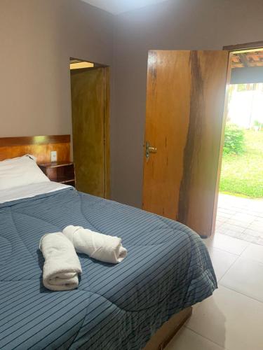 a bedroom with a bed with two towels on it at Pousada Sitio Roda D'Água Mairinque in Mairinque