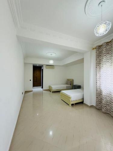 a large room with two beds and a hallway at appartement de vacances achakar plage & piscine & wifi in Tangier