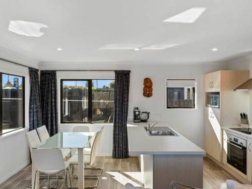a kitchen and dining room with a table and chairs at MiddleIsland-FREE & FAST wifi NETFLIX & aircon in Taupo