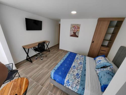 a bedroom with a bed and a desk at Moravia Coliving in Bogotá