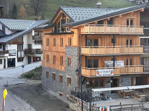 - un grand bâtiment en bois avec des balcons sur le côté dans l'établissement Appartement cozy 3 pièces avec terrasse et parking au centre, près des pistes - FR-1-464-235, à Pralognan-la-Vanoise