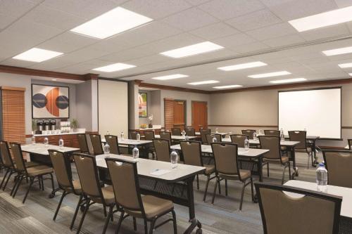 a conference room with tables and chairs and a whiteboard at Hyatt House Boston/Burlington in Burlington