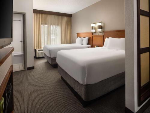 a hotel room with two beds and a flat screen tv at Hyatt Place Columbus/Dublin in Dublin