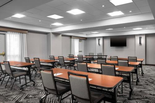 a conference room with tables and chairs and a screen at Hyatt Place Dallas North by the Galleria in Addison