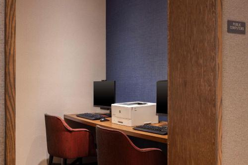 a desk with two computer monitors and a printer at Hyatt Place Sterling Dulles Airport North in Sterling