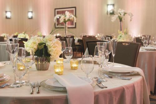 a table with plates and glasses and flowers on it at Embassy Suites Saratoga Springs in Saratoga Springs