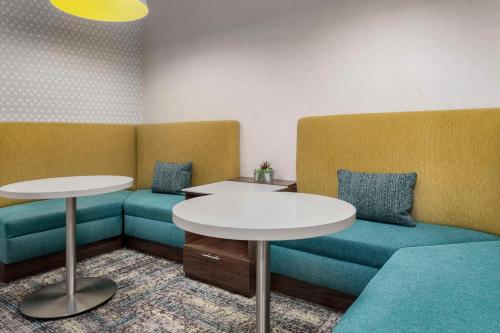a waiting room with two tables and blue seats at Hampton Inn Birmingham I-65/Lakeshore Drive in Birmingham