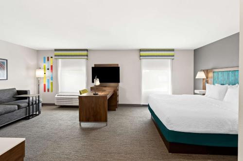 a hotel room with a bed and a couch at Hampton Inn & Suites Canton in North Canton