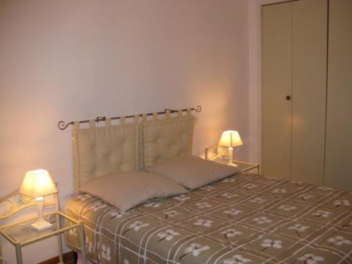 - une chambre avec un lit et 2 lampes sur les tables dans l'établissement Lugaro, à Calvi