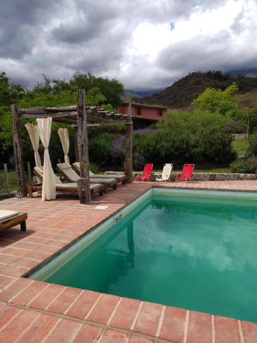 a swimming pool with chairs and a wooden pergola at VILLA ESPINA CHALET DE MONTAÑA a 8 km de San Javier in Villa de Las Rosas