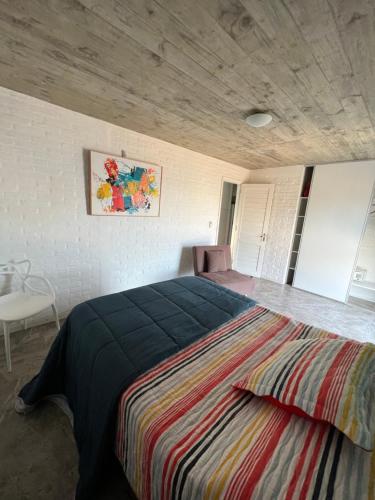 a bedroom with a large bed with a striped blanket at Las Olas Aparts in La Paloma
