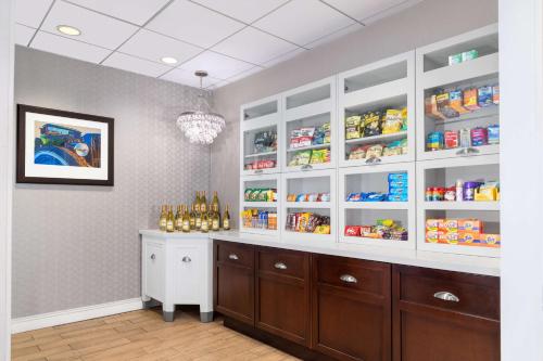 a kitchen with white cabinets and a counter with food at Homewood Suites by Hilton Detroit-Troy in Birmingham