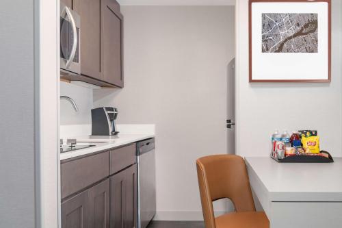 a small kitchen with a table and a chair at Homewood Suites by Hilton Detroit-Troy in Birmingham