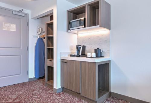 a small kitchen with a counter and a microwave at Hilton Garden Inn Dallas Arlington in Arlington