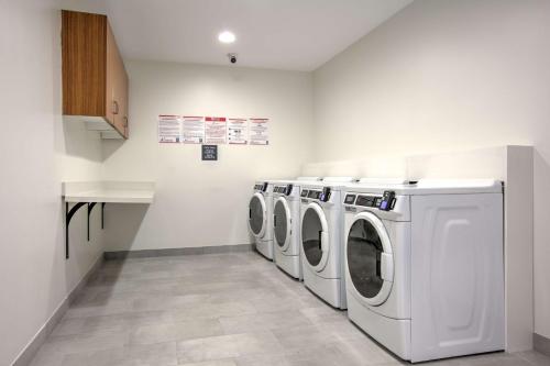 a laundry room with two washing machines and a counter at Hilton Garden Inn Dallas Arlington in Arlington