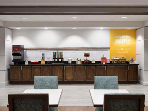 a waiting room with tables and chairs and a counter at Hampton Inn Houston Near the Galleria in Houston