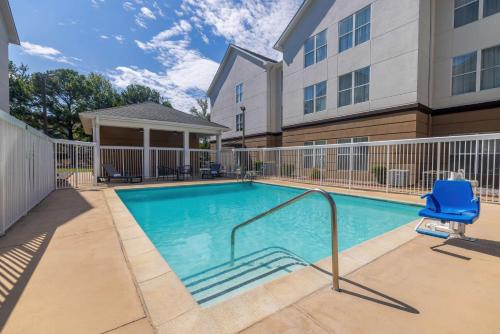 a swimming pool with a blue chair next to a building at Homewood Suites by Hilton Jackson-Ridgeland in Ridgeland