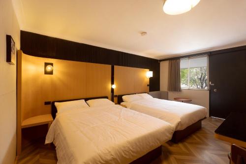 库纳巴拉布兰Mu S Boutique Motel "Matthew Flinders"的有两张床和一扇窗户的酒店房间