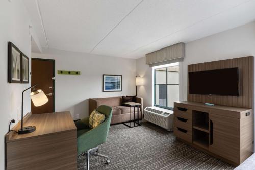 a living room with a couch and a flat screen tv at Hampton Inn & Suites Lake George in Lake George