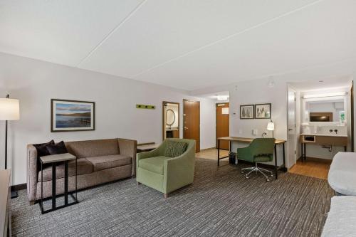 a hotel room with a couch and a desk at Hampton Inn & Suites Lake George in Lake George