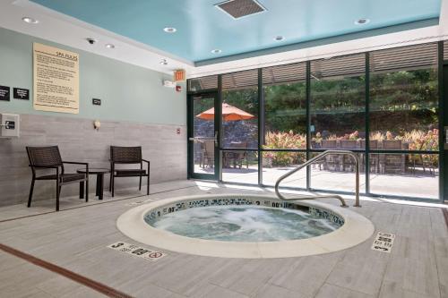 a hot tub in a room with a table and chairs at Hampton Inn & Suites Lake George in Lake George