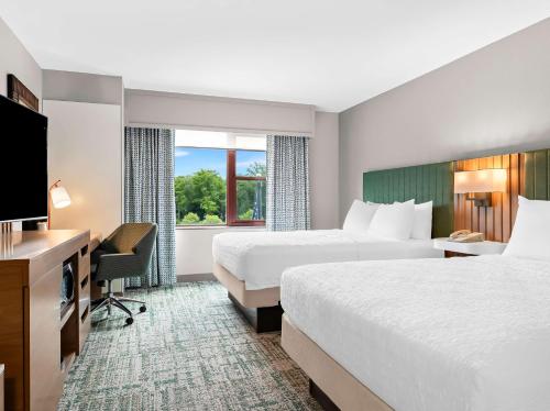 a hotel room with two beds and a television at Hampton Inn & Suites Lake Placid in Lake Placid