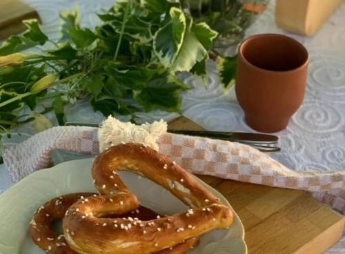 a plate of pretzel on a table with a cup of coffee at Ferienwohnung Rose in Peißenberg