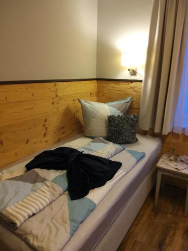 a bed with a wooden headboard and pillows on it at Ferienwohnung Rose in Peißenberg