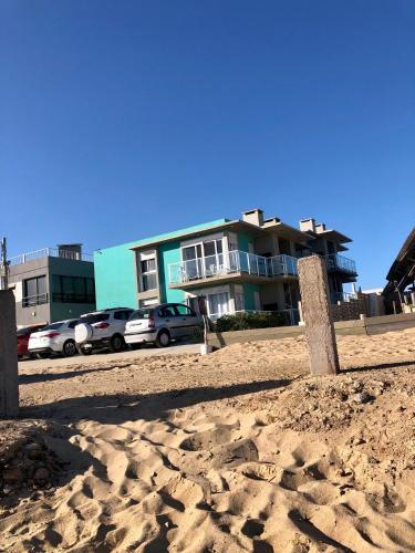 a building on the beach with cars parked in front at Las Olas Aparts in La Paloma