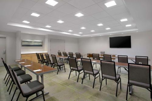 ein Konferenzraum mit Tischen und Stühlen und einer Leinwand in der Unterkunft Home2 Suites By Hilton Omaha West in Omaha