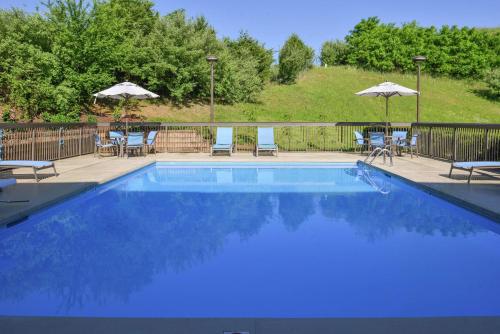 a large blue swimming pool with chairs and umbrellas at Hampton Inn Staunton in Staunton