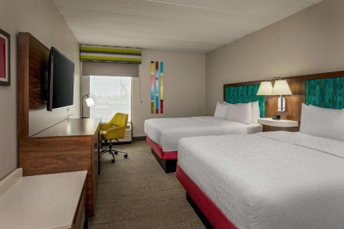 a hotel room with two beds and a desk at Hampton Inn Rehoboth Beach in Rehoboth Beach
