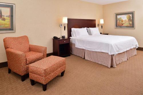 a hotel room with a bed and a chair at Hampton Inn Staunton in Staunton