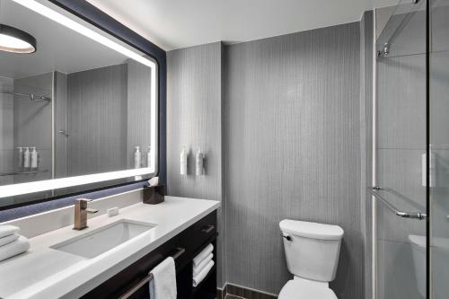 a bathroom with a sink and a toilet and a mirror at Homewood Suites Savannah Historic District/Riverfront in Savannah
