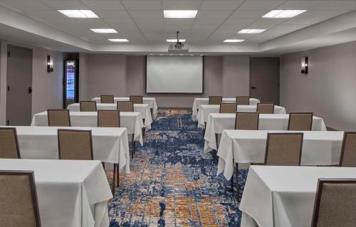 a conference room with white tables and chairs and a screen at Homewood Suites Savannah Historic District/Riverfront in Savannah