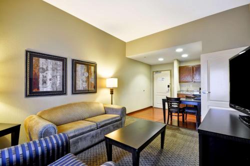 a living room with a couch and a table at Homewood Suites by Hilton Tulsa-South in Broken Arrow