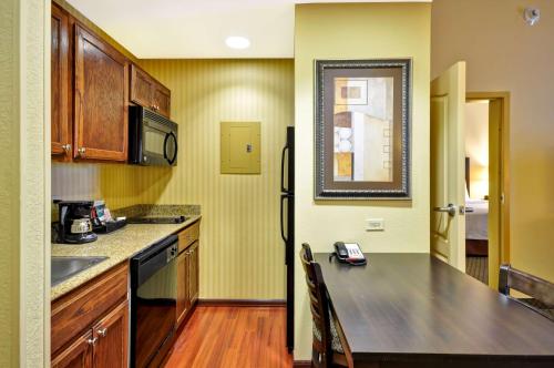 a kitchen with a counter top and a refrigerator at Homewood Suites by Hilton Tulsa-South in Broken Arrow