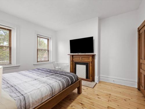 a bedroom with a bed and a flat screen tv at Oakland, Pittsburgh !C Bright and Stylish Private Bedroom with Shared Bathroom in Pittsburgh