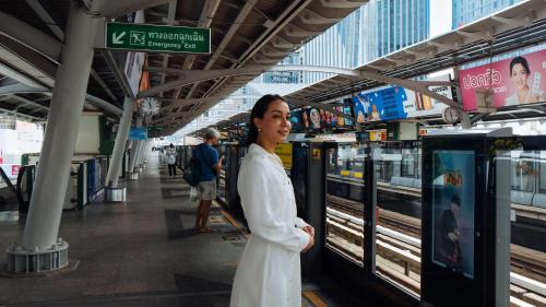 a woman standing in a subway station with a train at DoubleTree by Hilton Sukhumvit Bangkok in Bangkok