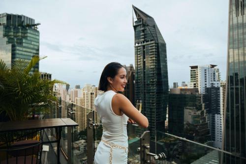 a woman in a white dress looking at the city at DoubleTree by Hilton Sukhumvit Bangkok in Bangkok