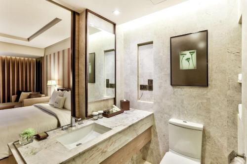 a bathroom with a bed and a sink and a mirror at DoubleTree by Hilton Sukhumvit Bangkok in Bangkok