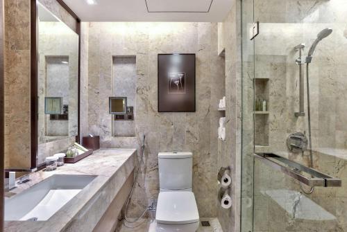 a bathroom with a toilet and a sink and a shower at DoubleTree by Hilton Sukhumvit Bangkok in Bangkok