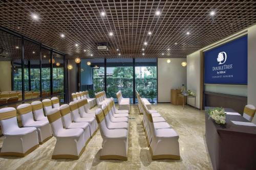 a waiting room with white chairs and a stage at DoubleTree by Hilton Sukhumvit Bangkok in Bangkok