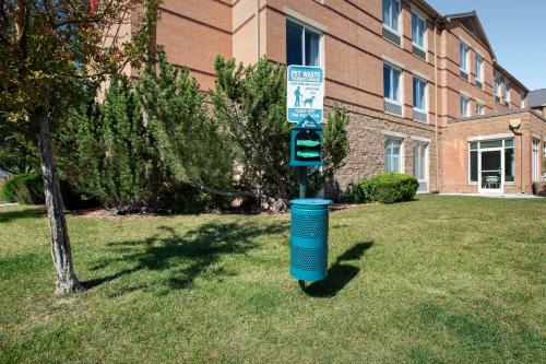 a blue trash can sitting in the grass in front of a building at Hilton Garden Inn Colorado Springs North in Colorado Springs