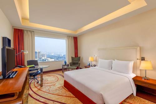 a hotel room with a large bed and a desk at DoubleTree by Hilton Gurgaon New Delhi NCR in Gurgaon