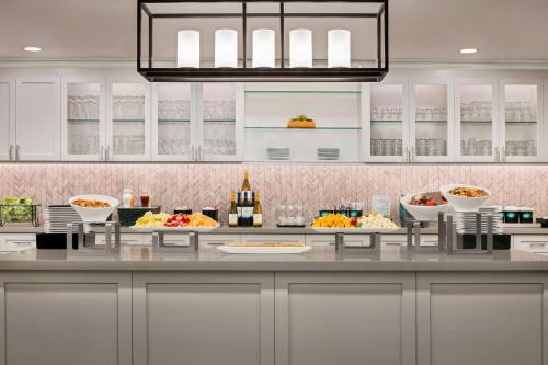 a kitchen with a buffet of food and bottles of wine at Homewood Suites by Hilton Fort Myers in Fort Myers