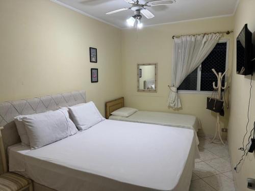 グアルジャにあるApartamento com vista marのベッド2台と天井ファン付きの寝室