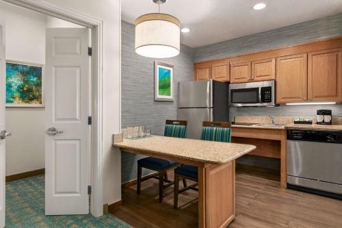 a kitchen with a table and chairs and a refrigerator at Homewood Suites by Hilton Fort Myers in Fort Myers